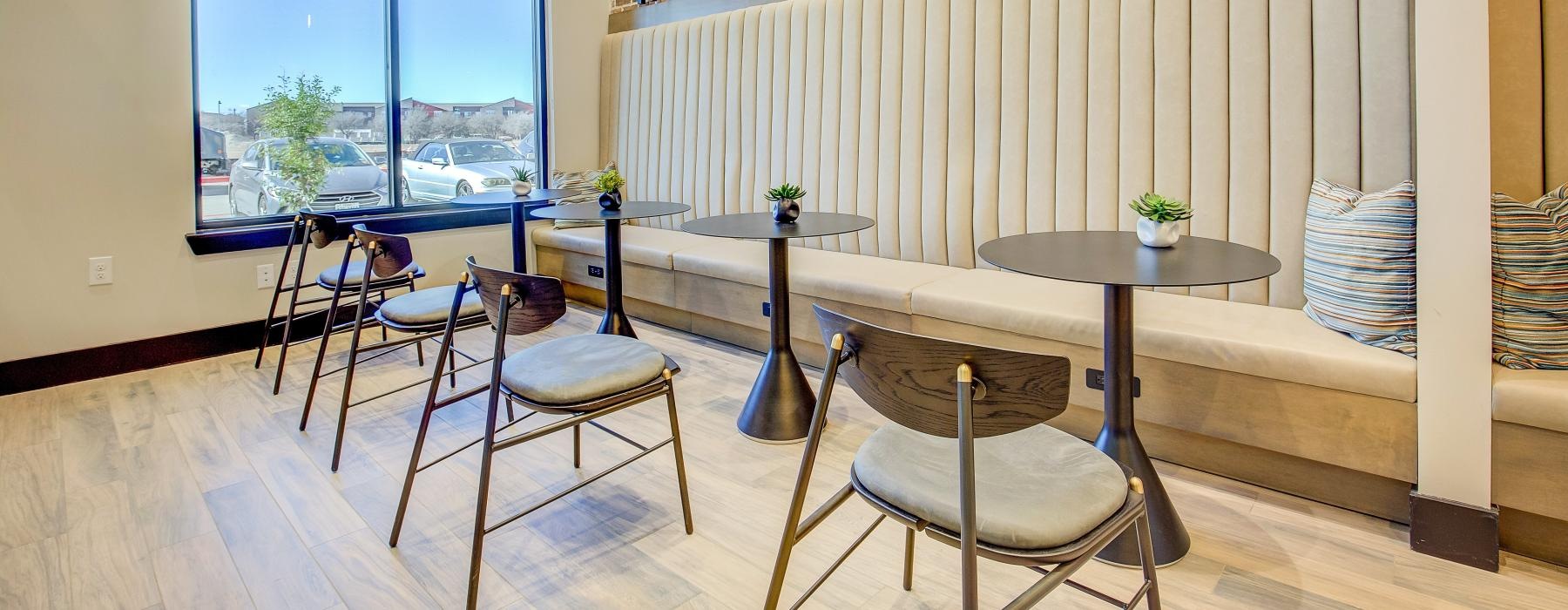 a room with a table chairs and a window